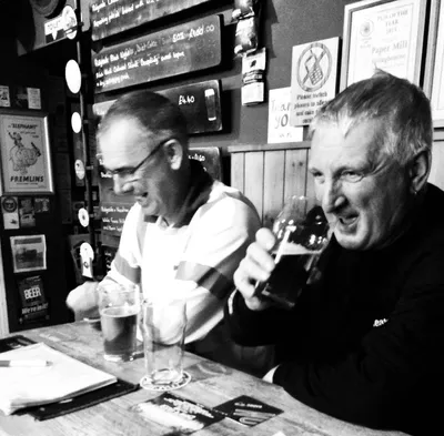 Two men chatting over drinks at table