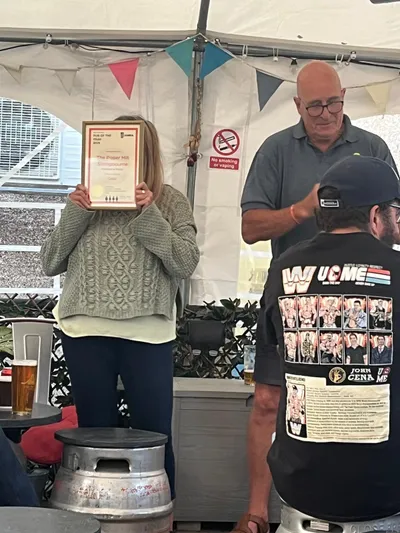 Person holding pub award certificate