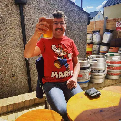 Man in Mario shirt raising pint glass